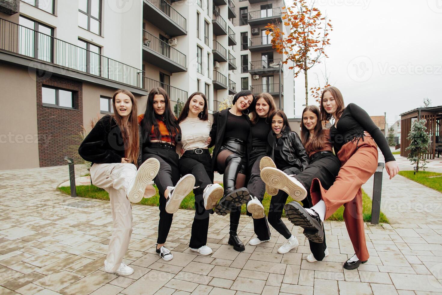 groupe de beaucoup content adolescents habillé dans décontractée vêtements ayant amusement et ayant amusement près collège. concept de amitié, des moments de Bonheur. école relation amicale photo