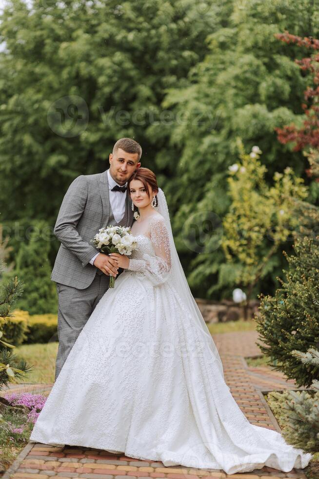 mariage. l'amour et couple dans jardin pour mariage. fête de la cérémonie et engagement. enregistrer le date. confiance. le la mariée et jeune marié embrasser. le jeune marié embrasse le la mariée dans le printemps paysage. photo