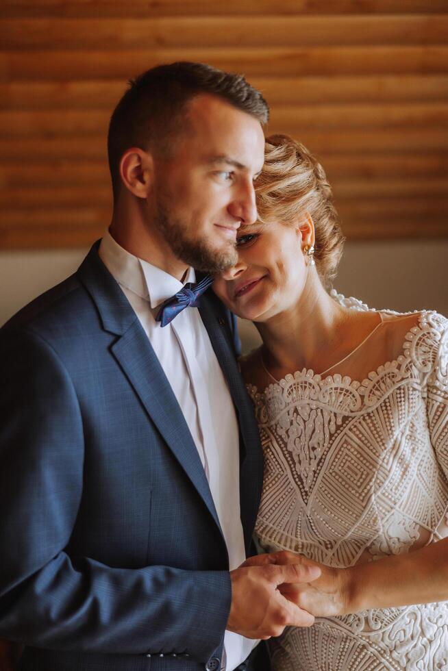 mère aide sa adulte fils préparer pour le mariage cérémonie. un émotif et émouvant moment à une mariage. une mère câlins sa fils photo