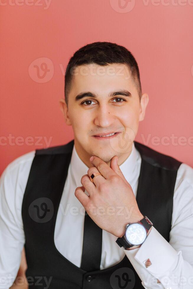 élégant portrait de le jeune marié. une homme prépare pour une mariage la cérémonie dans le Matin. du marié Matin. préparation pour le du marié Matin. Jeune et Beau jeune marié dans une élégant costume. photo