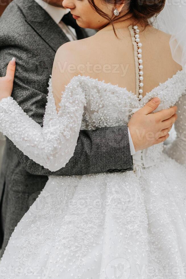 portrait. le jeune marié embrasse le la mariée. une homme main sur une femme épaules. hiver mariage photo