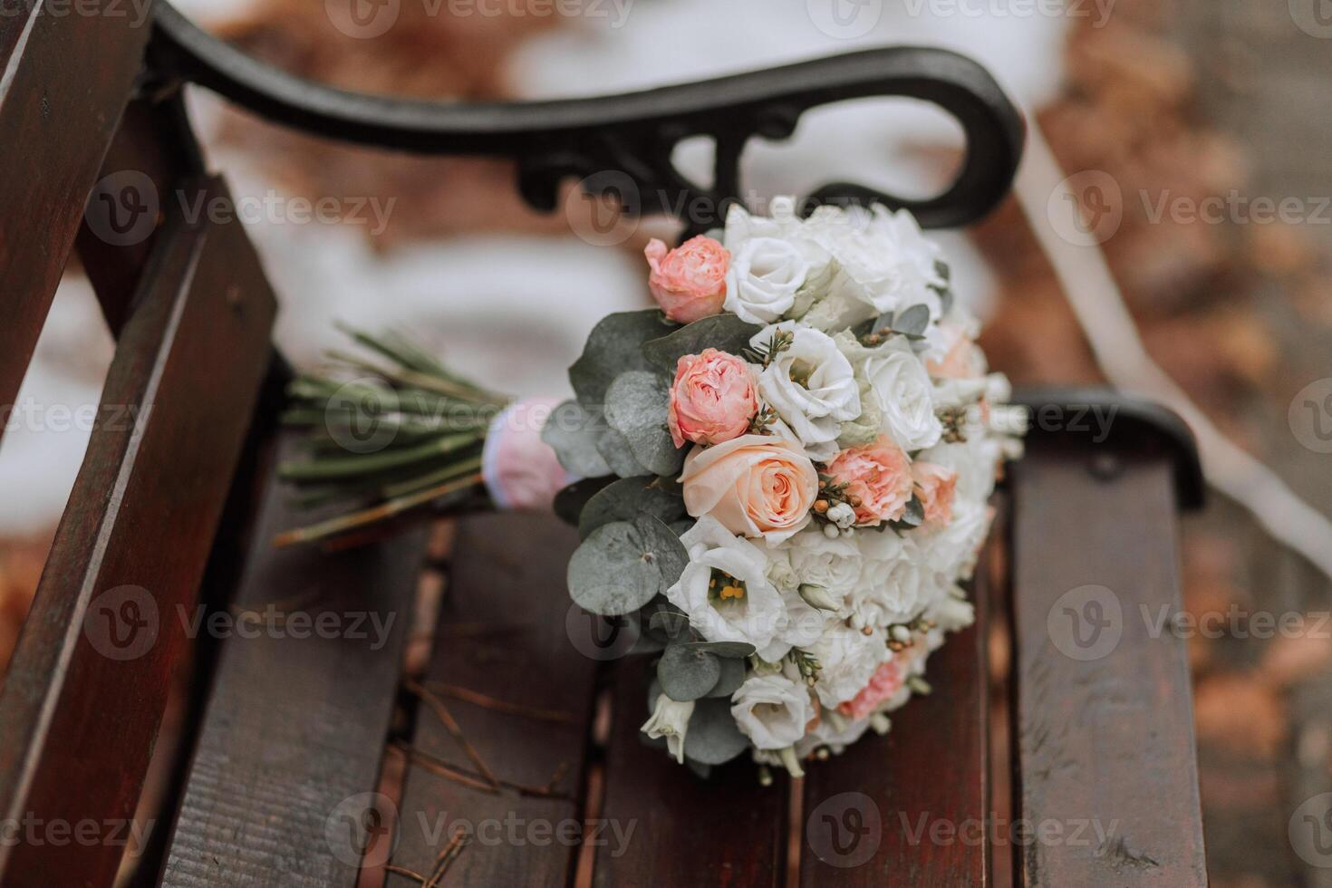 le de la mariée bouquet sur une marron banc. hiver mariage. une marcher dans le forêt photo