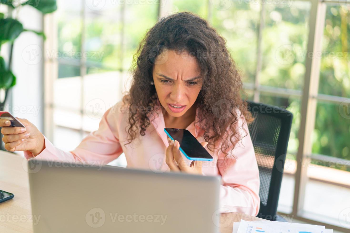 femme latine travaillant avec la main tenant la carte sur l'espace de travail photo