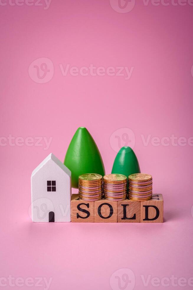 une petit en bois maison et le une inscription vendu. concept pour vente, de location de réel biens pour une famille photo