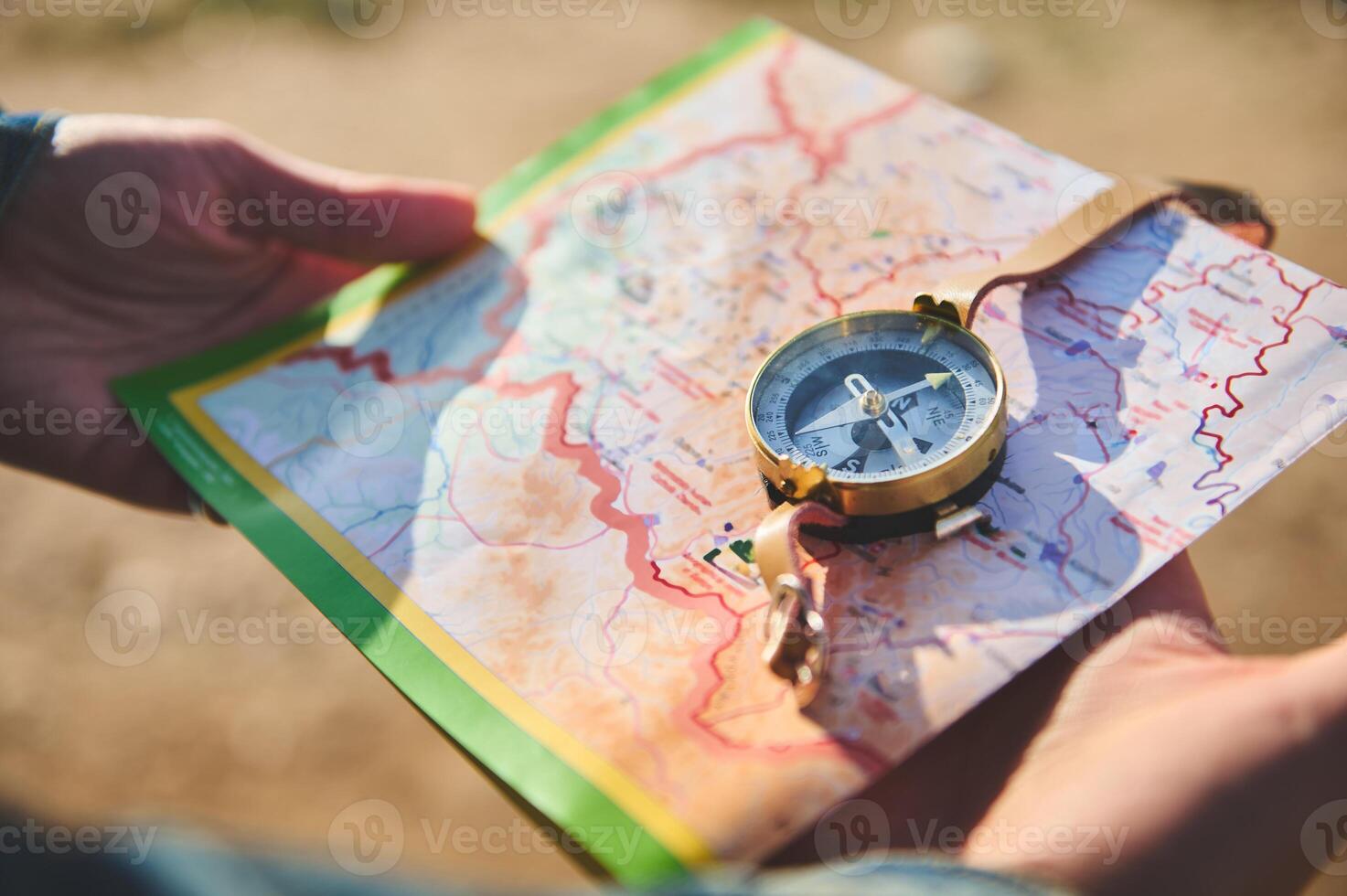 fermer de du voyageur mains en portant carte et en utilisant boussole, recherche direction tandis que randonnée, explorant la nature photo