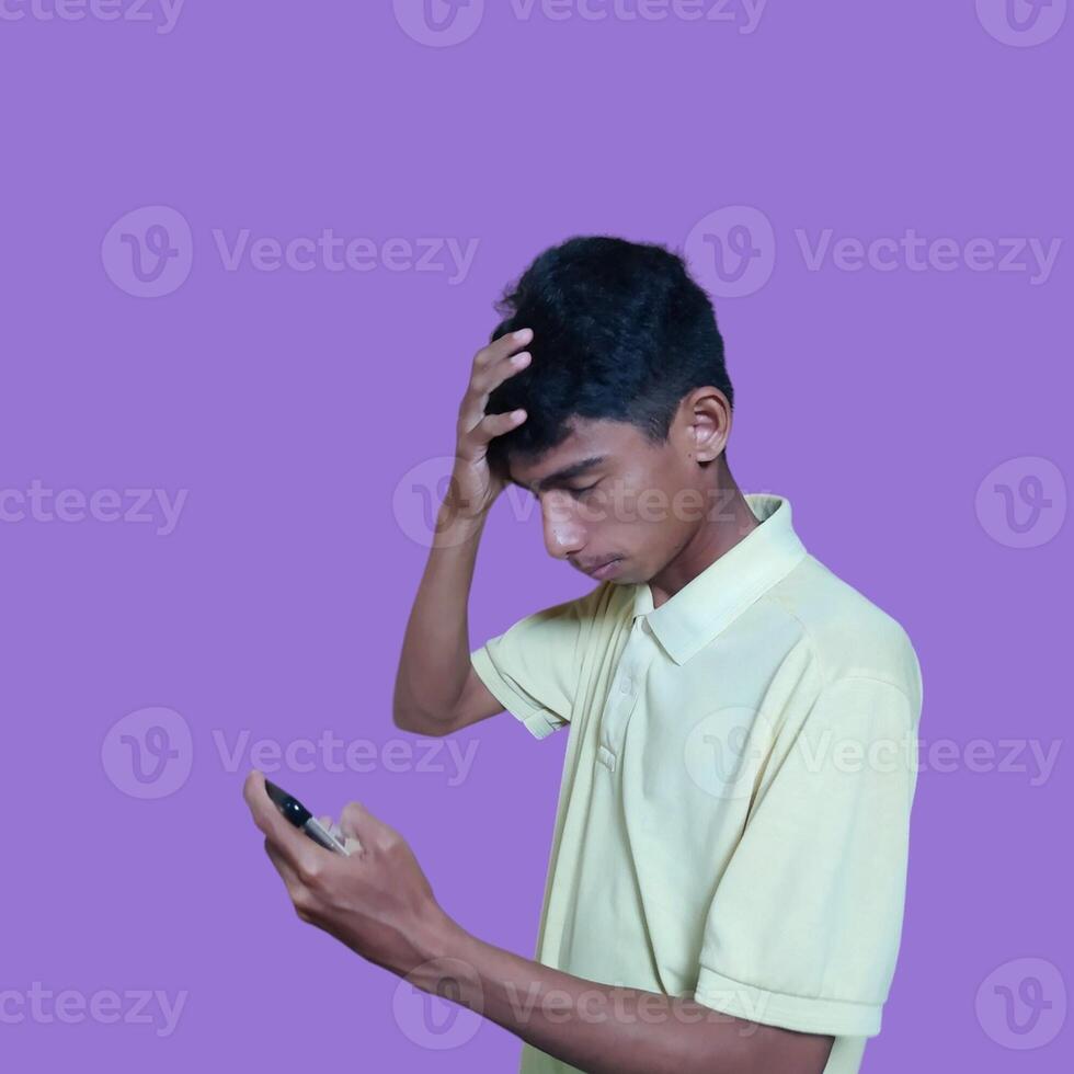 étourdi visage en portant tête de Jeune asiatique homme dans Jaune chemise isolé sur violet Contexte photo