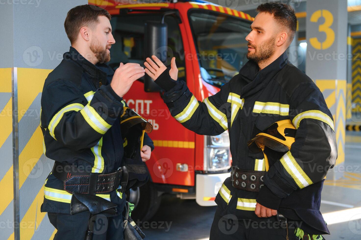 deux sapeurs pompiers dans protecteur Vêtements dans casques avec Feu moteur photo