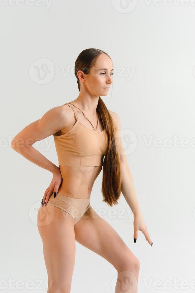 image de une pompé en haut abdos. magnifique sportif femme posant dans studio sur une blanc Contexte. aptitude, la musculation, aérobie concept. photo