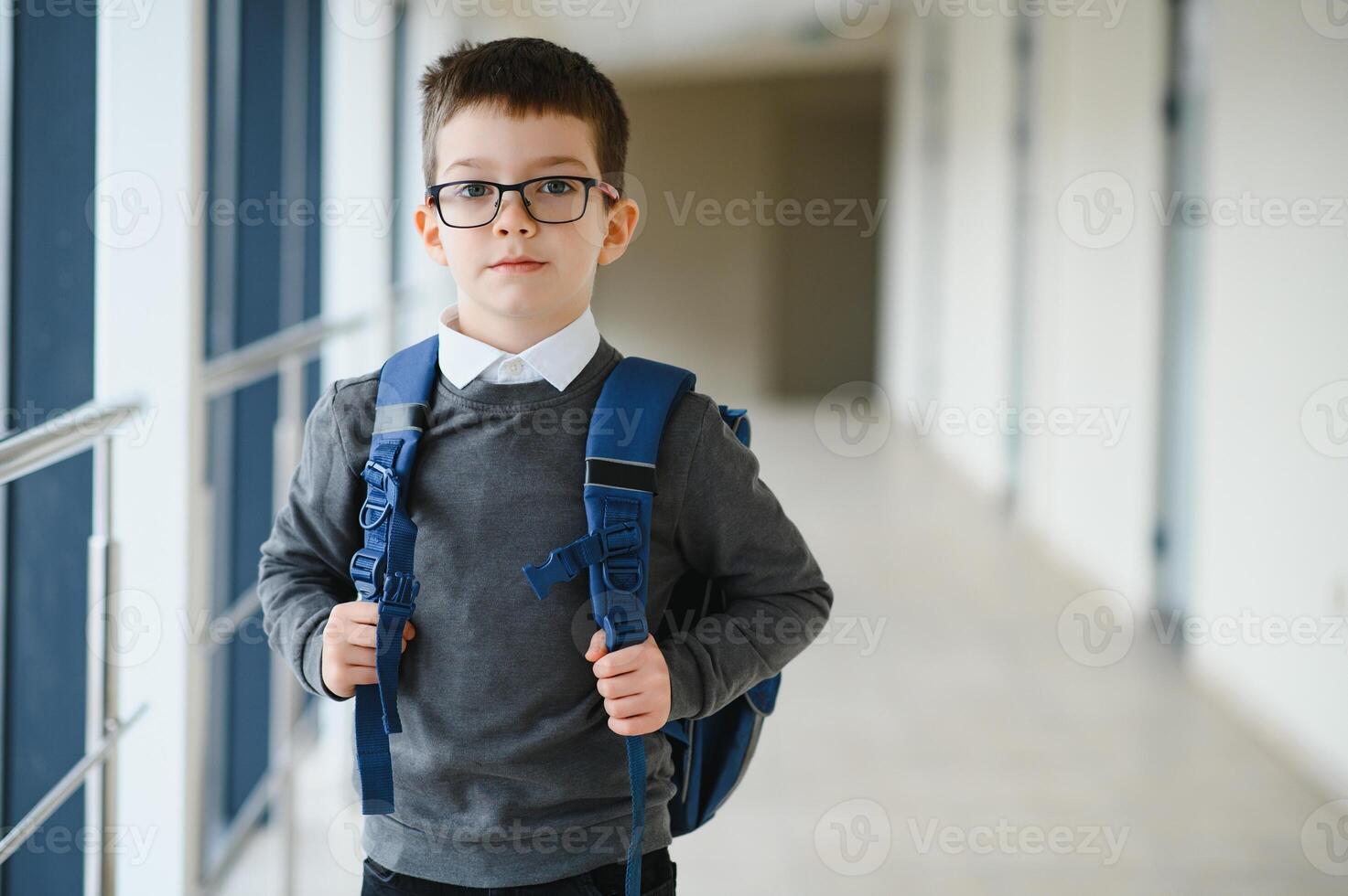 écolier avec cartable et livres dans le école. éducation concept. retour à école. écolier Aller à classe. élégant garçon avec sac à dos. garçon prêt à étude. photo