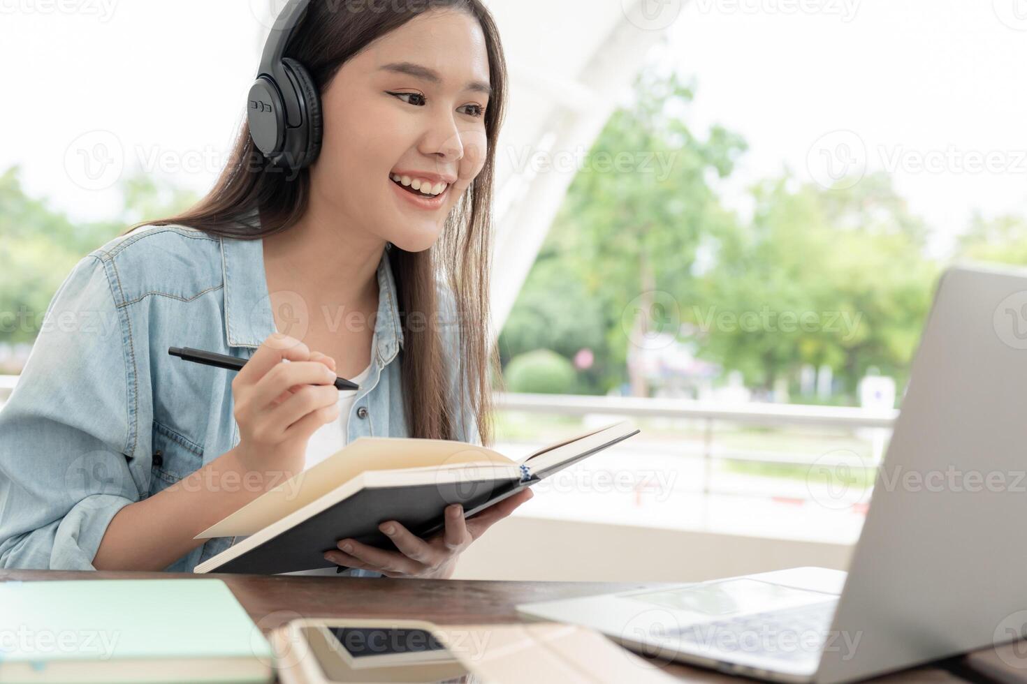 belle femme asiatique étudiante excitée vérifiant les résultats des tests de langue sur ordinateur portable. sourire fille heureuse étude en ligne. réserver sur le campus universitaire. portrait féminin sur l'université internationale d'asie. photo