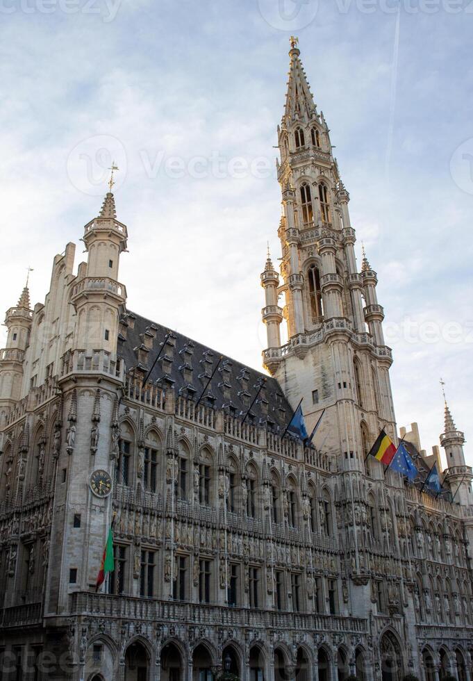 balayage vue de Bruxelles ville salle avec l'horloge la tour et trio de drapeaux - grandiose lieux gothique bijou photo