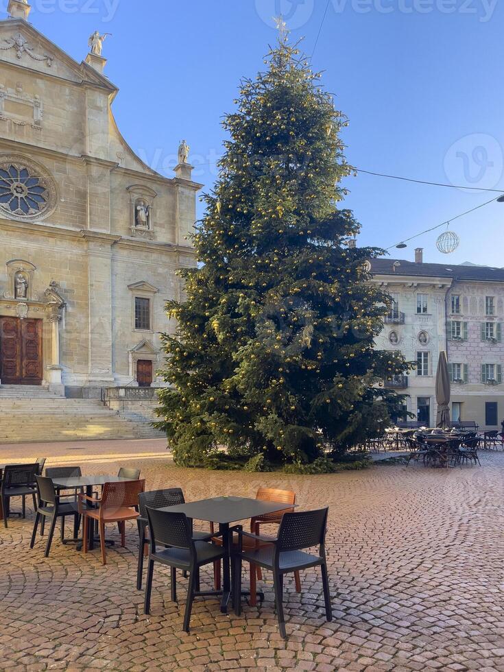 une grand Noël arbre dans le milieu de une place photo