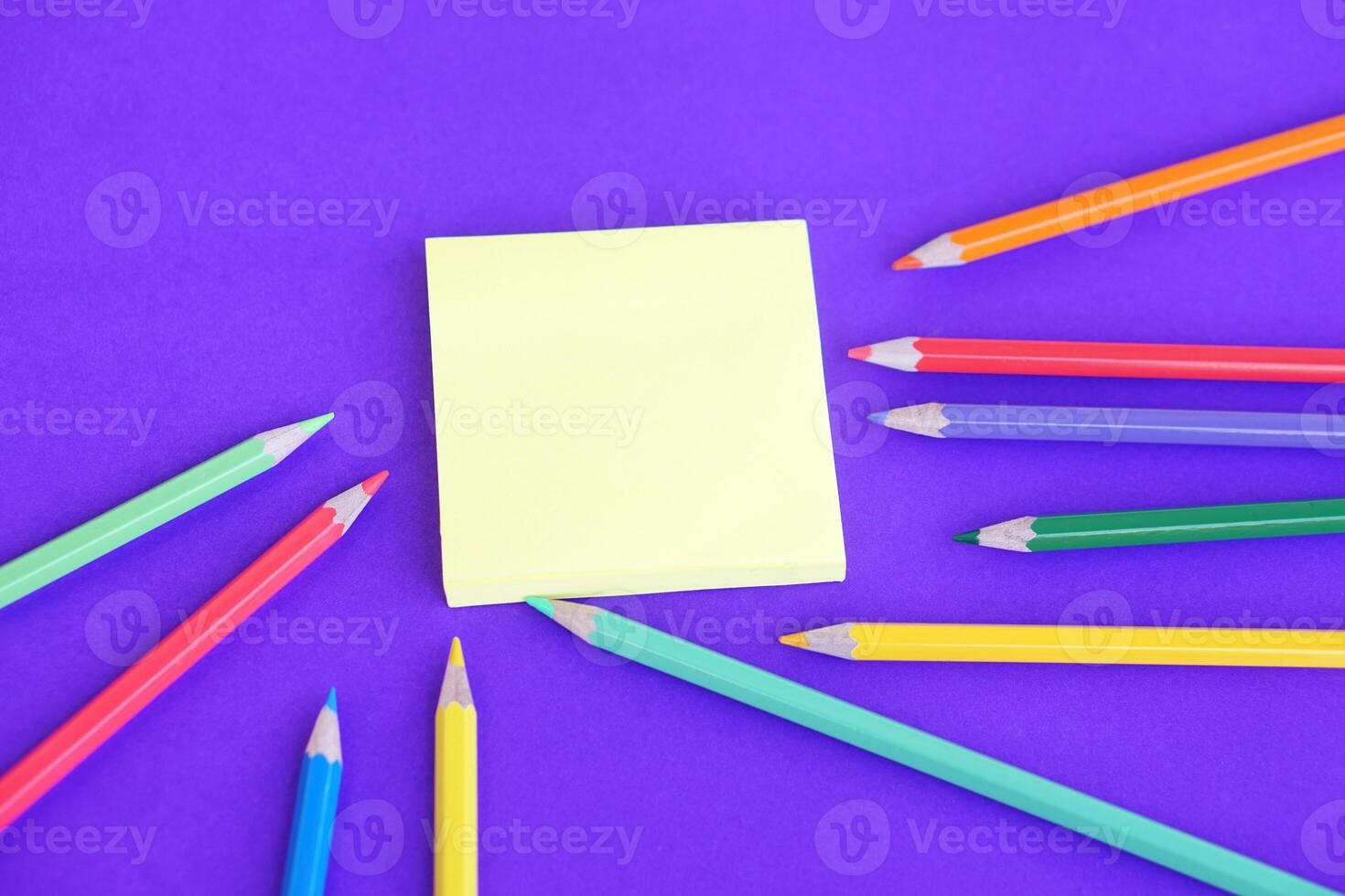 Couleur des crayons et papier bloc-notes sur violet Contexte. concept, éducatif matériaux, art. prise note, faire des plans, rappel. photo