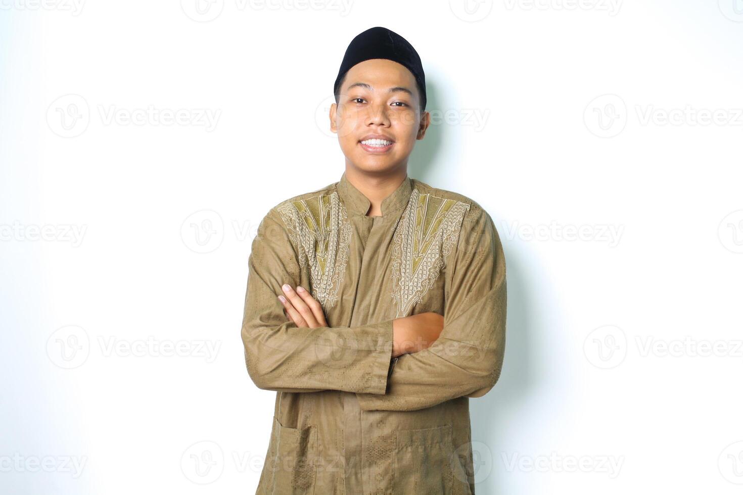 souriant asiatique musulman homme permanent sur isolé blanc Contexte avec plié bras et souriant confiance portant koko vêtements islamique robe photo