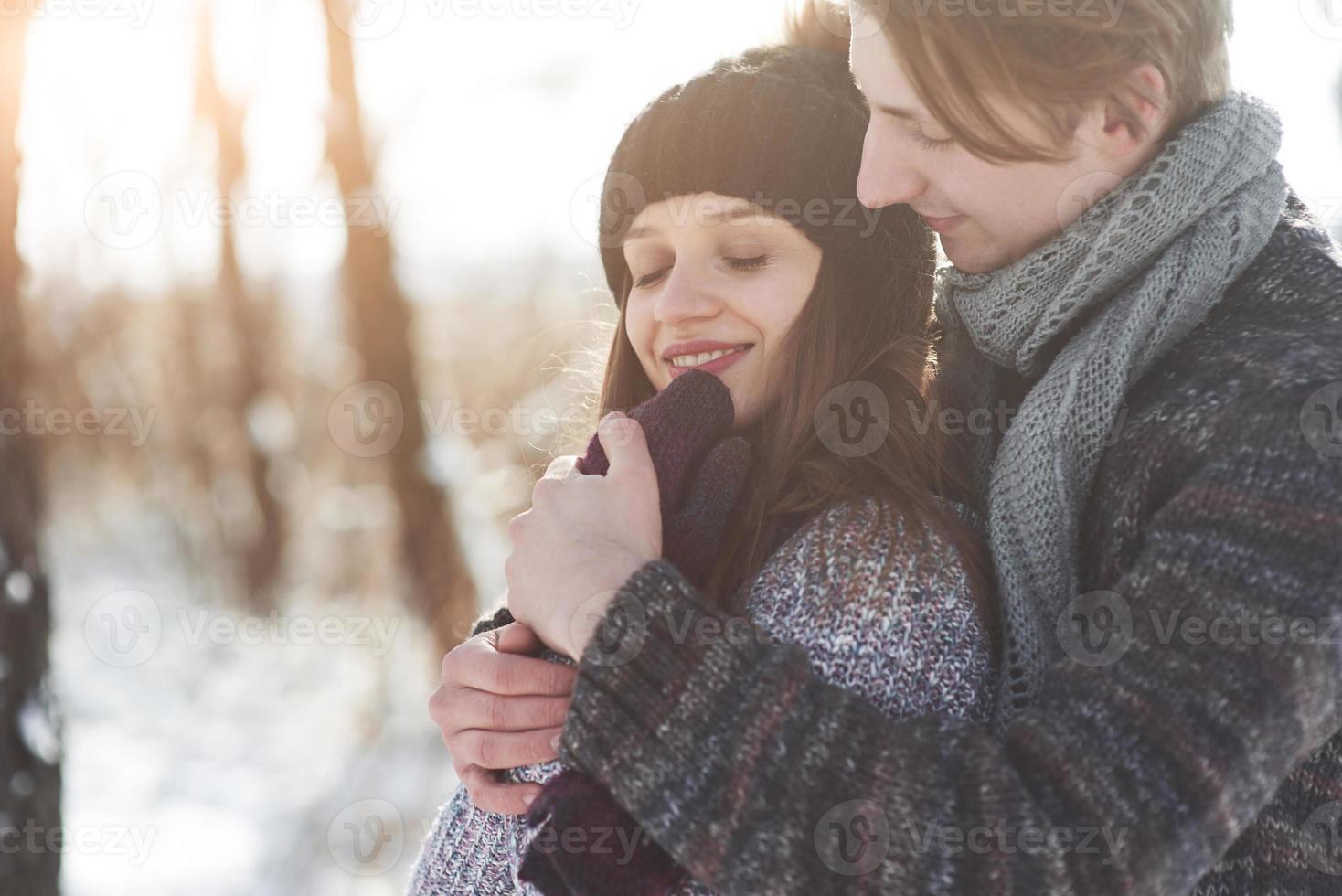 le couple s'amuse et rit. embrasser. jeune couple hipster s'embrassant dans le parc d'hiver. histoire d'amour d'hiver, un beau jeune couple élégant. concept de mode d'hiver avec petit ami et petite amie photo