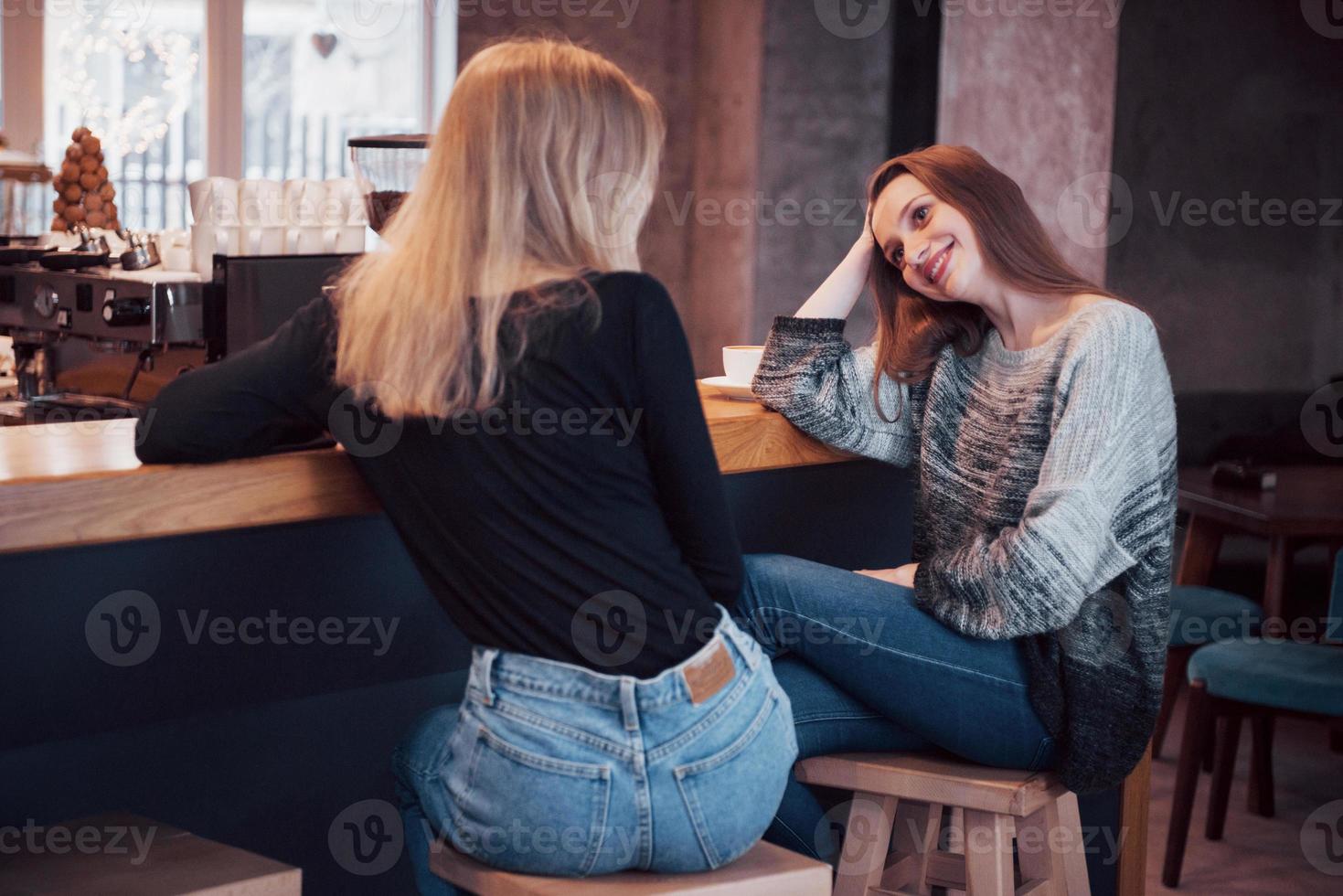 photo tonique des meilleurs amis ayant rendez-vous dans un café ou un restaurant. belles filles parlant ou communiquant en buvant du café