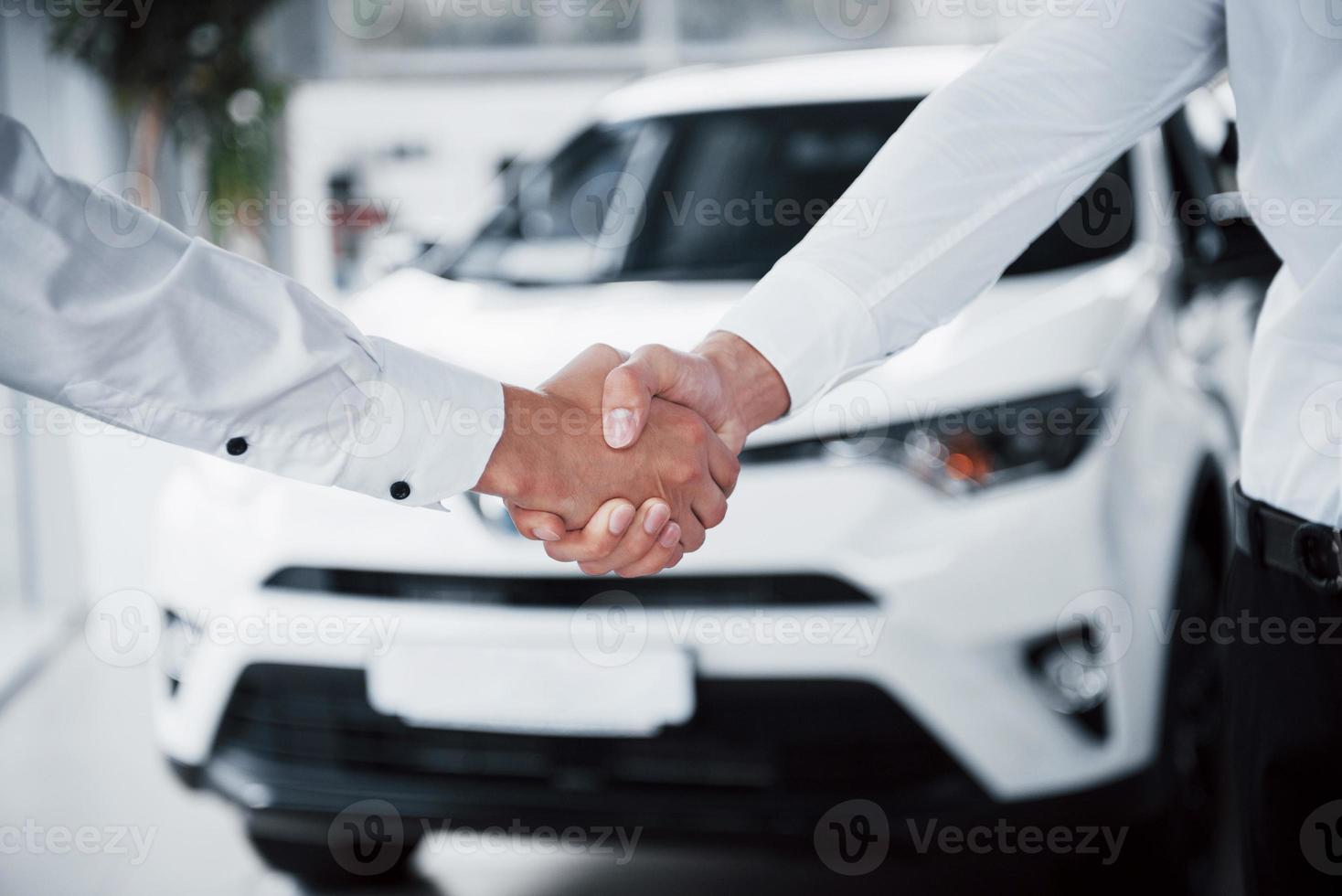 gros plan du directeur des ventes en costume noir vendant la voiture au client photo