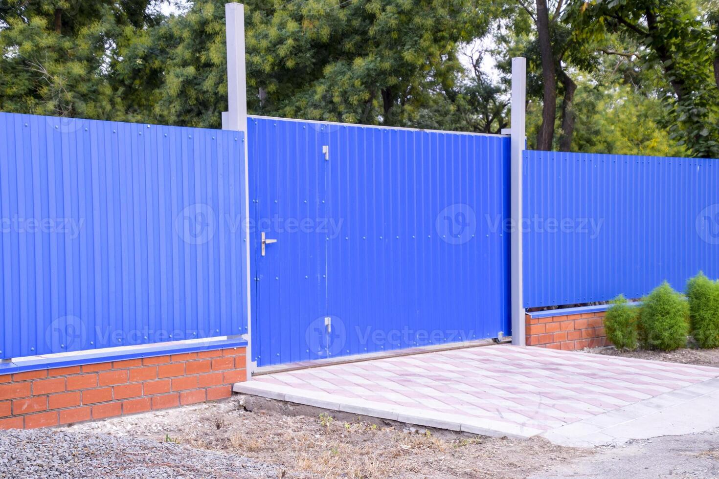 clôture et porte de feuilles de bleu ondulé métal. photo