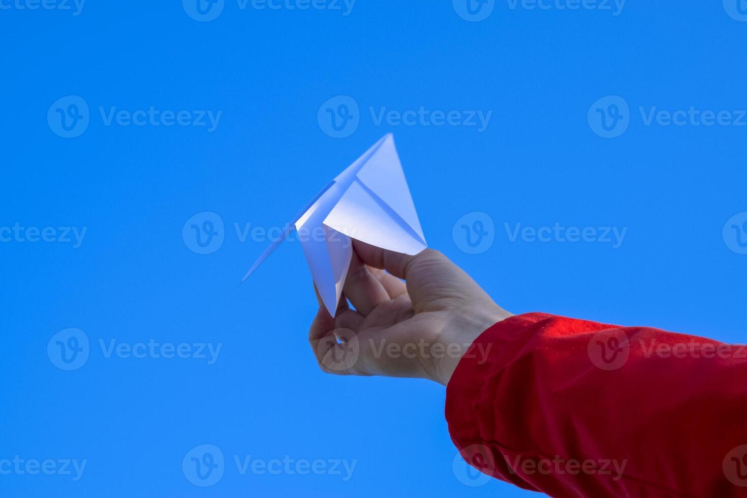 blanc papier avion dans main contre le ciel. une symbole de liberté sur le l'Internet photo