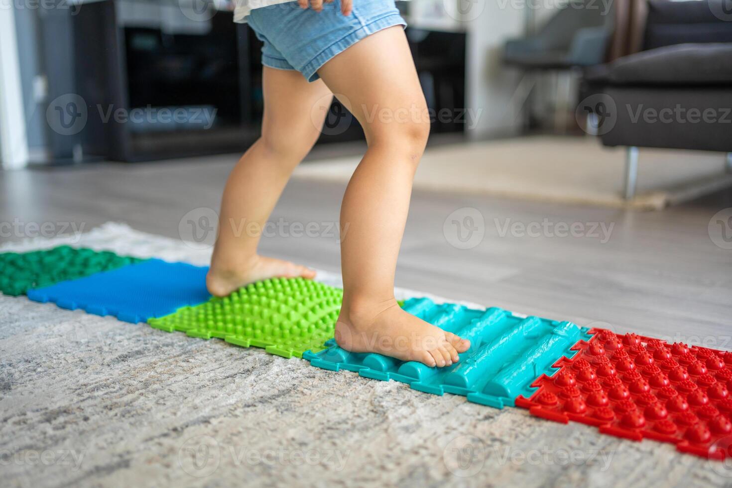 proche en haut vue de peu fille des promenades sur une massage tapis. bambin bébé pied massage tapis. des exercices pour jambes orthopédique massage tapis. photo