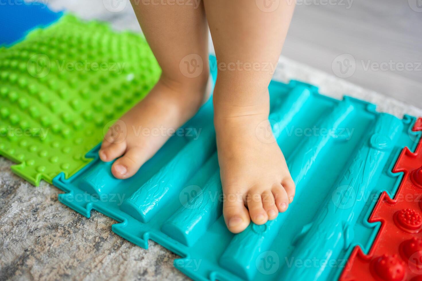 proche en haut vue de peu fille des promenades sur une massage tapis. bambin bébé pied massage tapis. des exercices pour jambes orthopédique massage tapis. photo