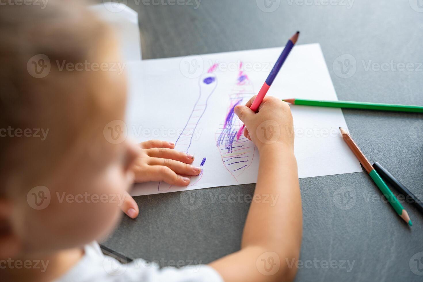 peu fille dessine avec coloré des crayons dans maison. photo