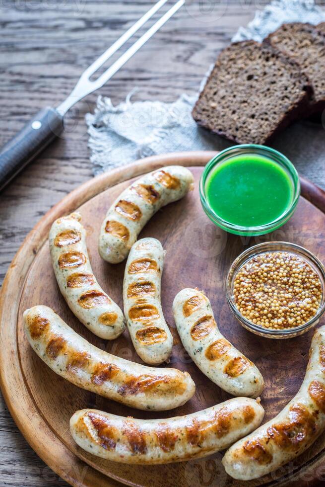 grillé saucisses avec chaud sauces sur le en bois planche photo