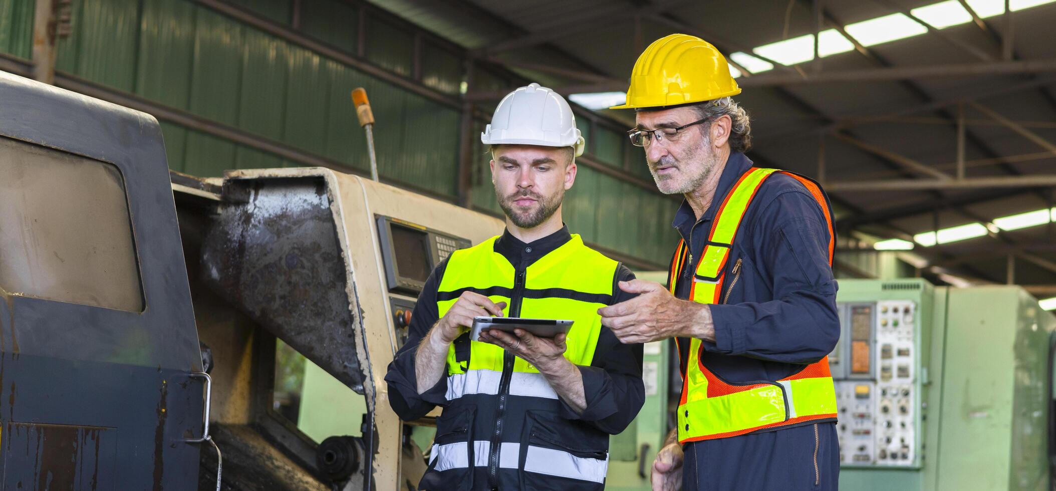 deux ingénieur Regardez projets et Planification avec tablette mobile dans usine photo