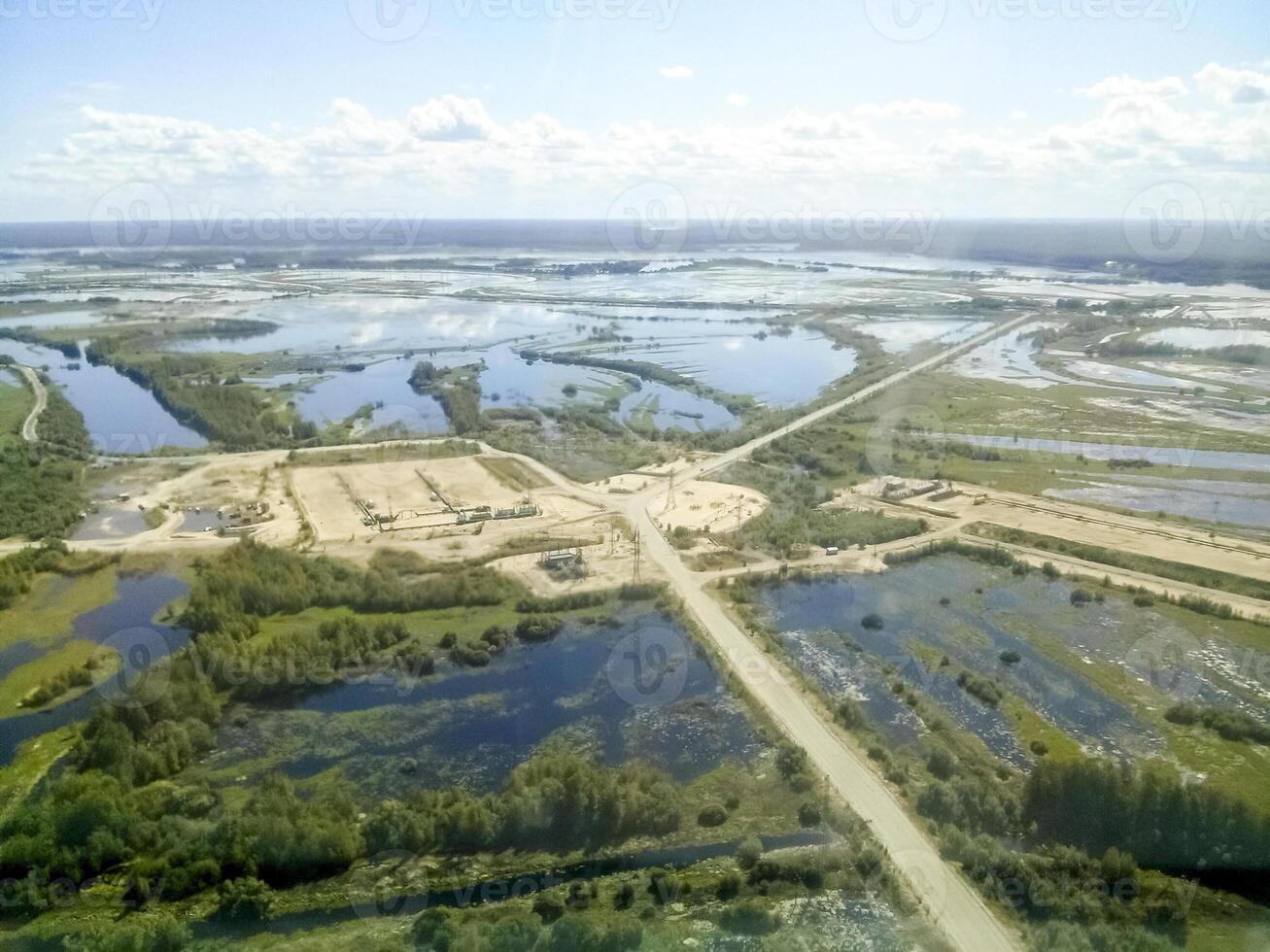 Haut vue de le pétrole et gaz champ. marécages et les entrées à industriel installations. photo