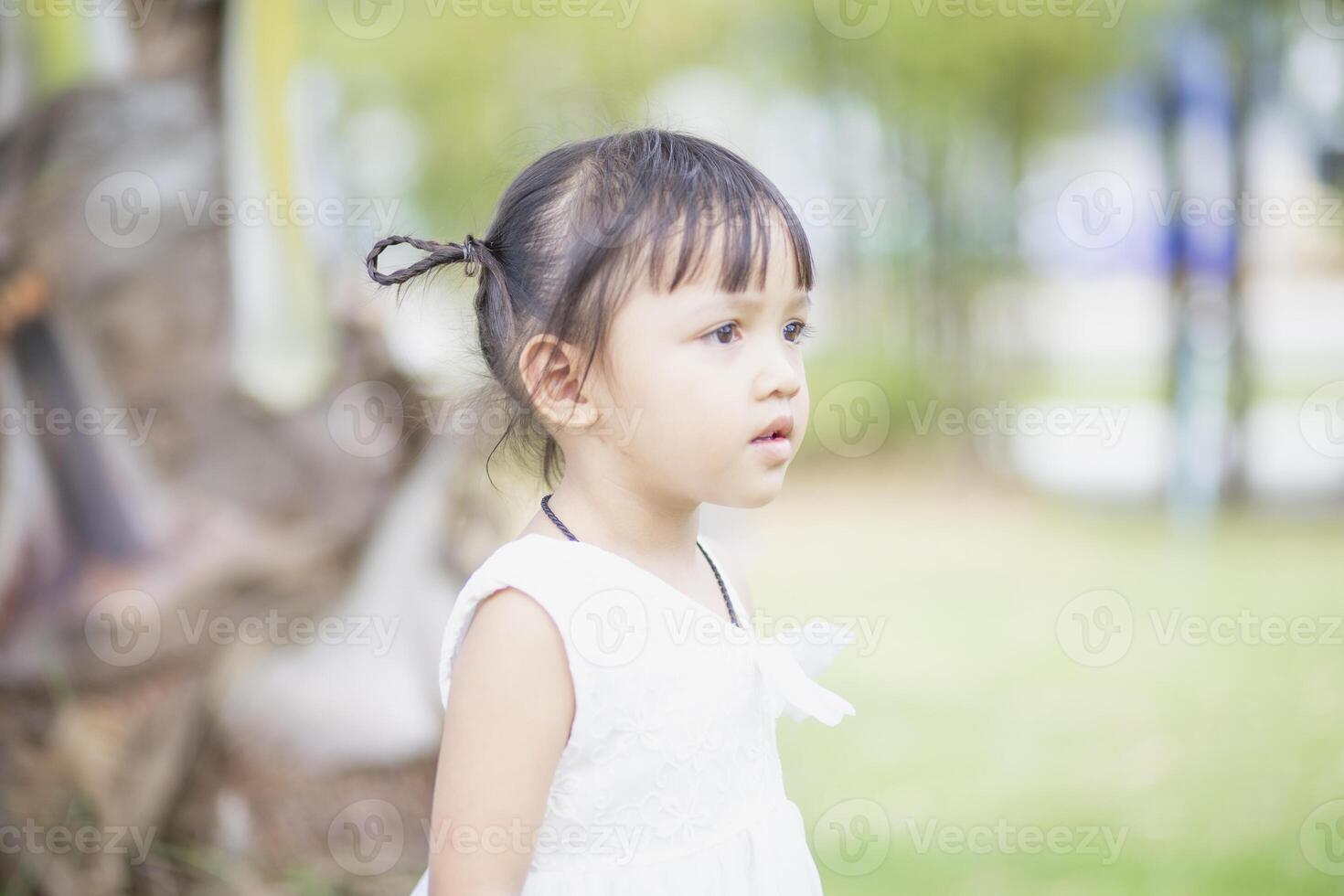 une content Jeune fille admire et doucement touche et admire une épanouissement fleur. il reflète le beauté de printemps et le Facile les plaisirs de étant dans contact avec la nature. printemps éveil. photo