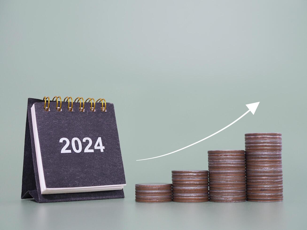 2024 bureau calendrier, empiler de pièces de monnaie avec La Flèche en hausse. le concept de affaires croissance, financier investissement, marché action, profit retour, dividende et affaires fonds dans année 2024 photo