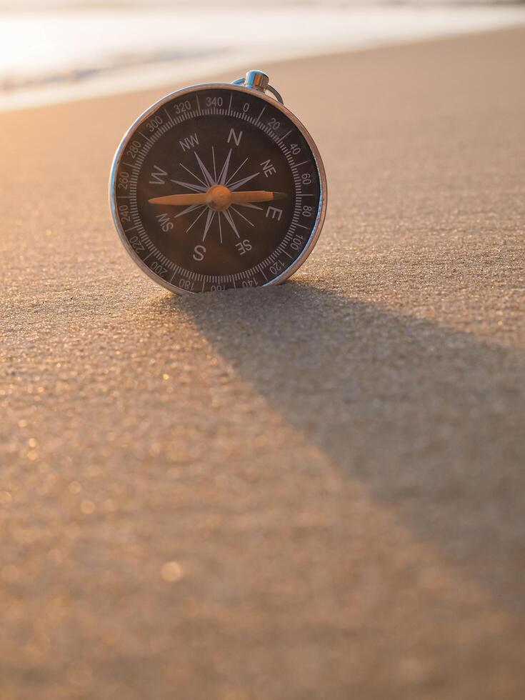 proche en haut boussole sur le plage avec lumière du soleil photo