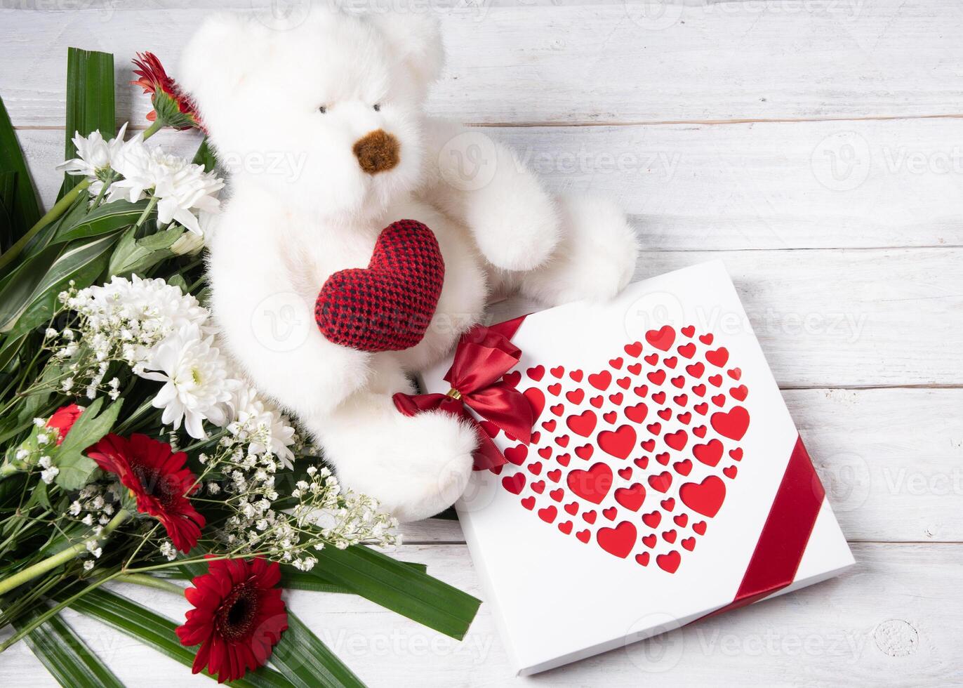 la Saint-Valentin journée cadeau, nounours ours avec une cœur, une boîte de pralines et une bouquet photo