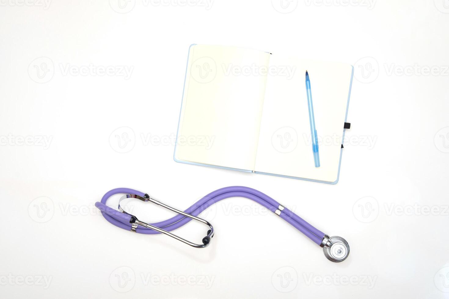 une lilas phonendoscope mensonges sur une table avec une bloc-notes et une stylo, vue de au dessus photo