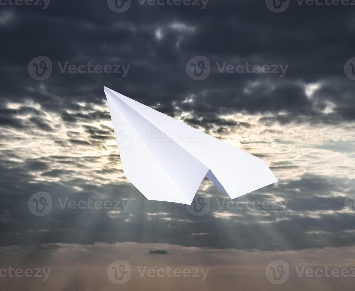 blanc papier avion dans une bleu ciel avec des nuages. le message symbole dans le Messager photo