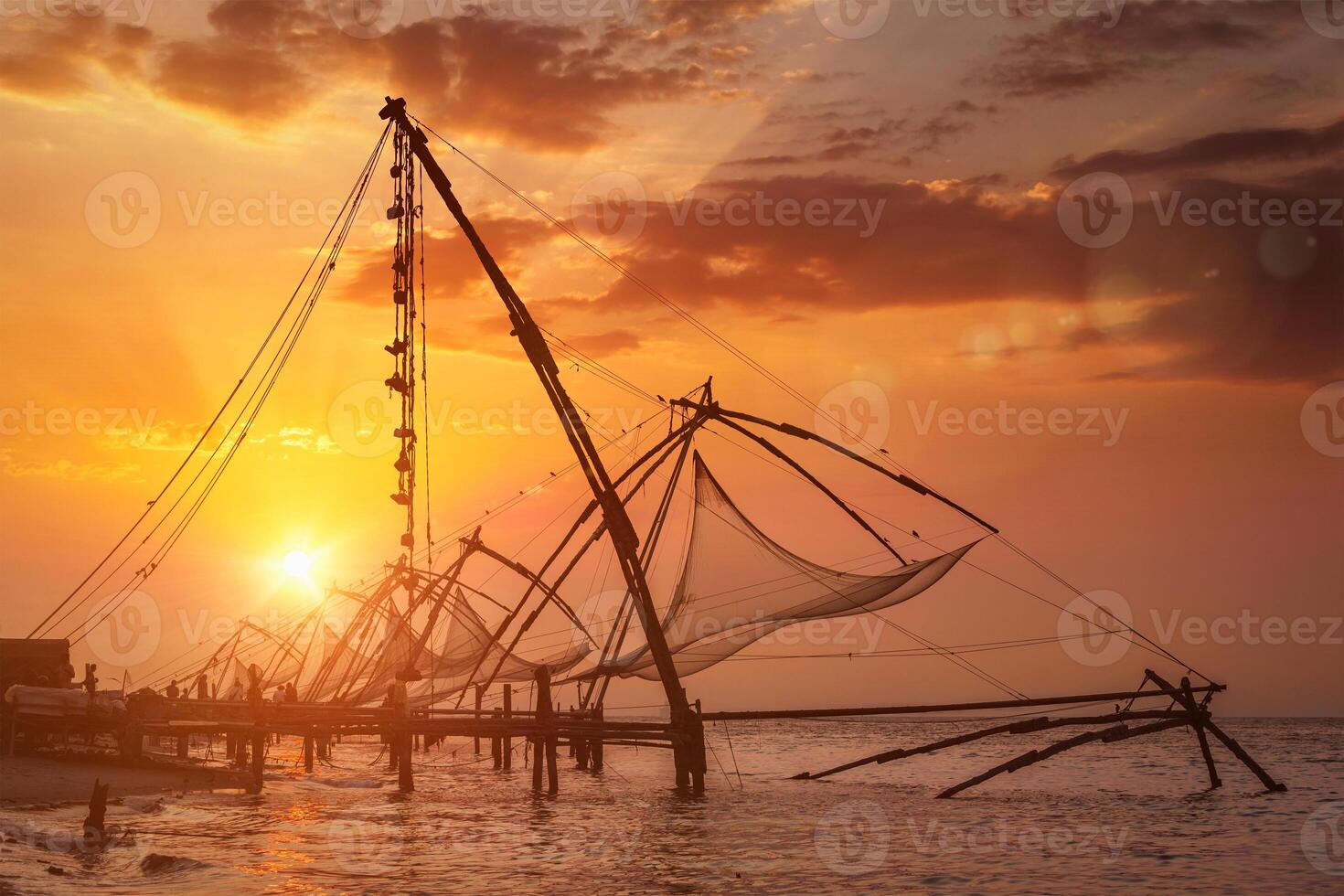 chinois filets de pêche sur le coucher du soleil. Kochi, Kerala, Inde photo