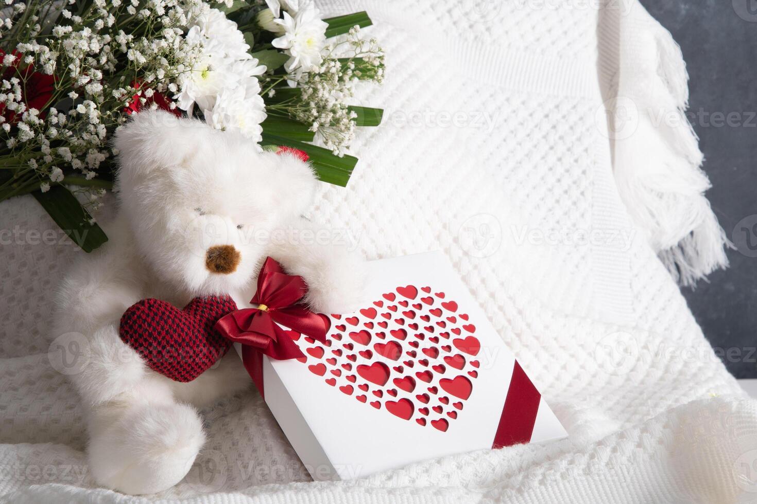 la Saint-Valentin journée cadeau, nounours ours avec une cœur, une boîte de pralines et une bouquet photo