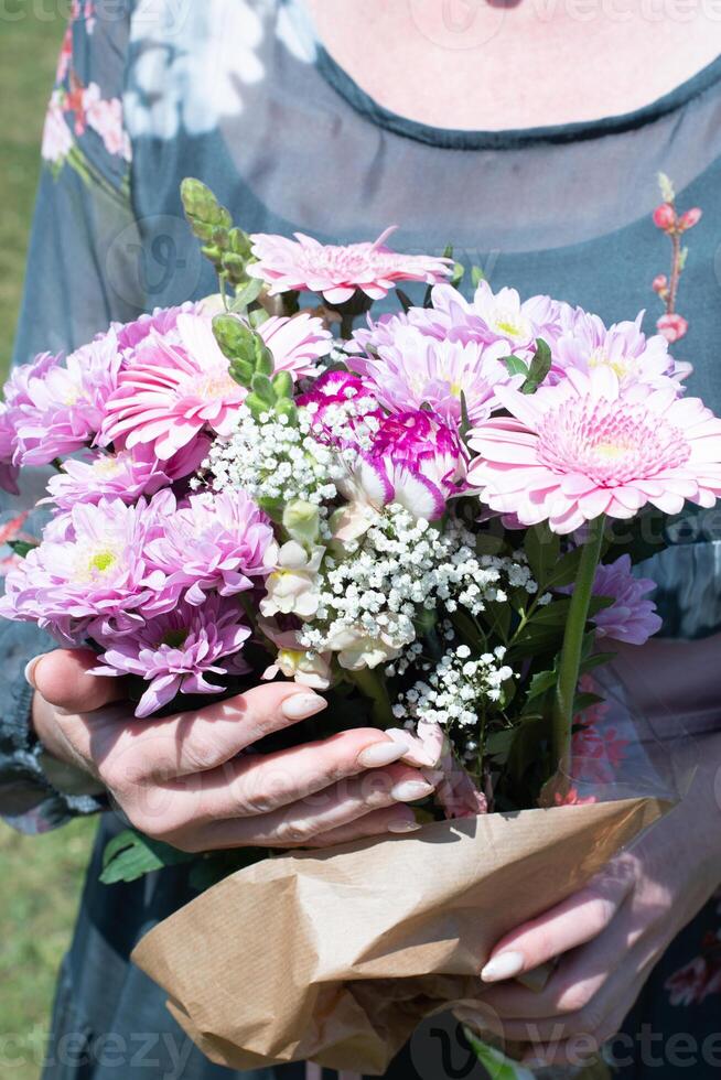 âge moyen femme avec une bouquet de rose Gerberas une cadeau pour de la mère jour, printemps photo