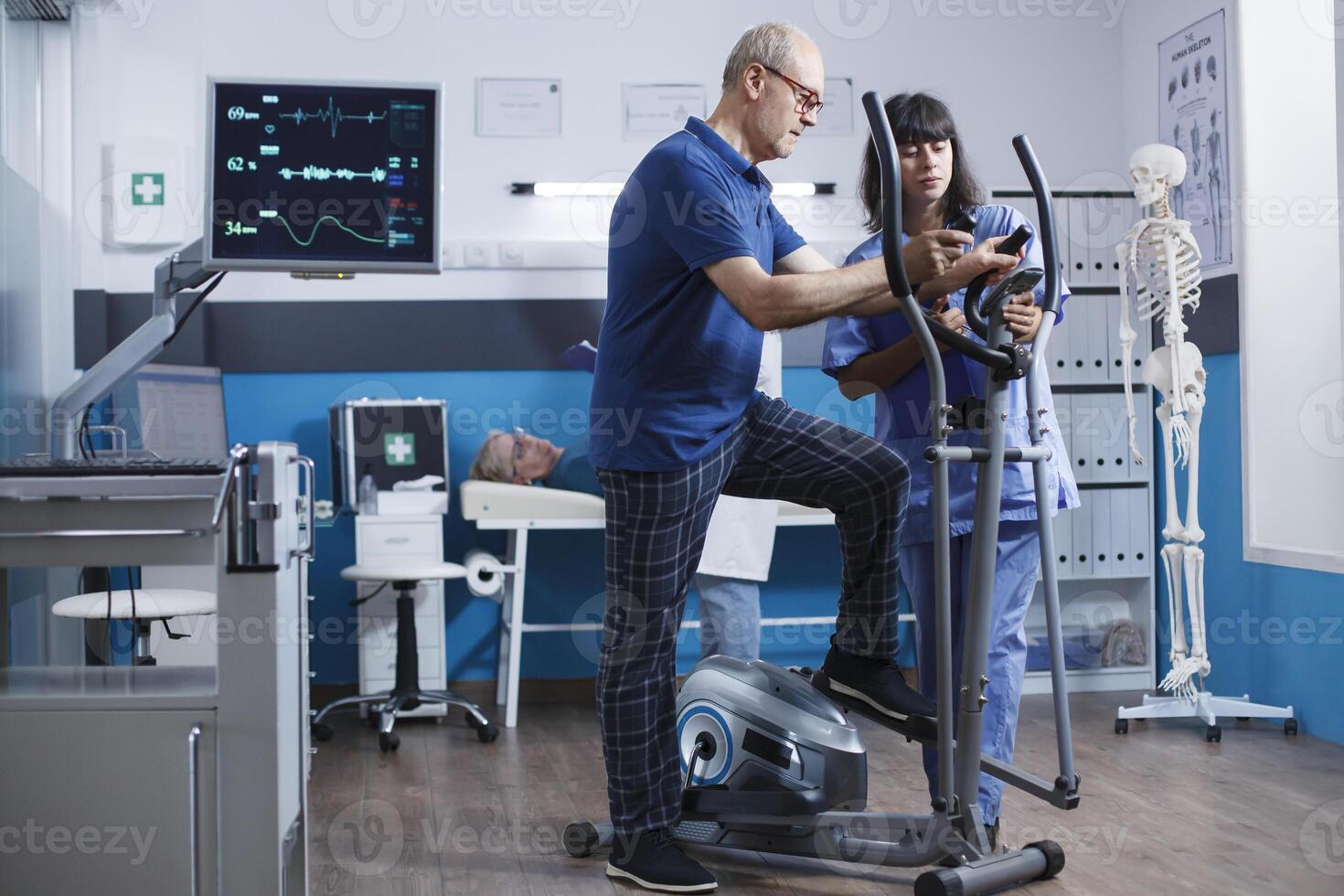 personnes âgées Masculin patient exercice et surveillance battement de coeur en utilisant une cœur taux moniteur à aide dans récupération. médical infirmière assiste Sénior la personne sur Stationnaire bicyclette pour physique traitement. photo