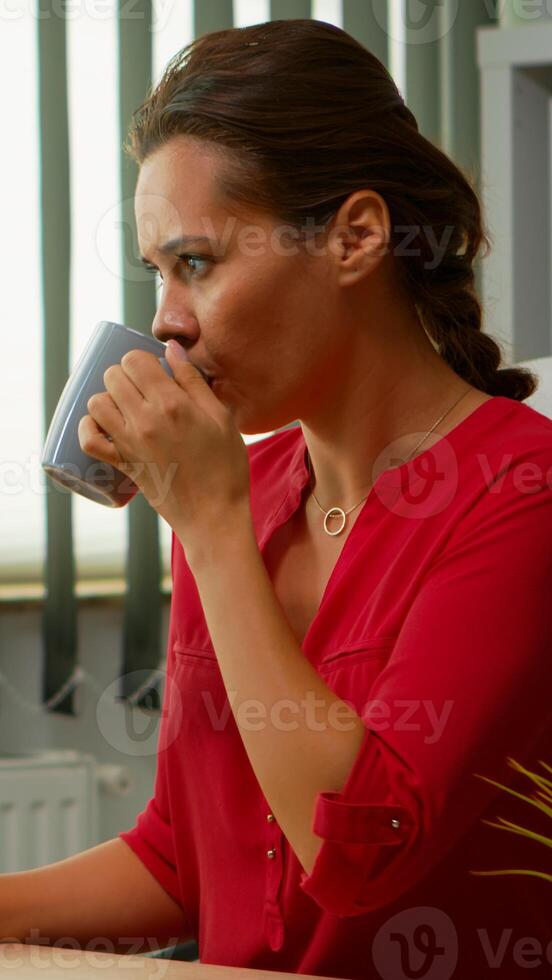 pigiste en buvant café à le Bureau et dactylographie à ordinateur dans spécial programme. entrepreneur travail dans moderne professionnel espace de travail lieu de travail dans entreprise entreprise avec sans fil ordinateur clavier photo