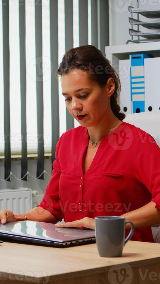 femme en utilisant portable et PC dans même temps dans Bureau chambre. entrepreneur travail dans moderne professionnel espace de travail, lieu de travail dans personnel entreprise entreprise dactylographie sur ordinateur clavier à la recherche à bureau photo