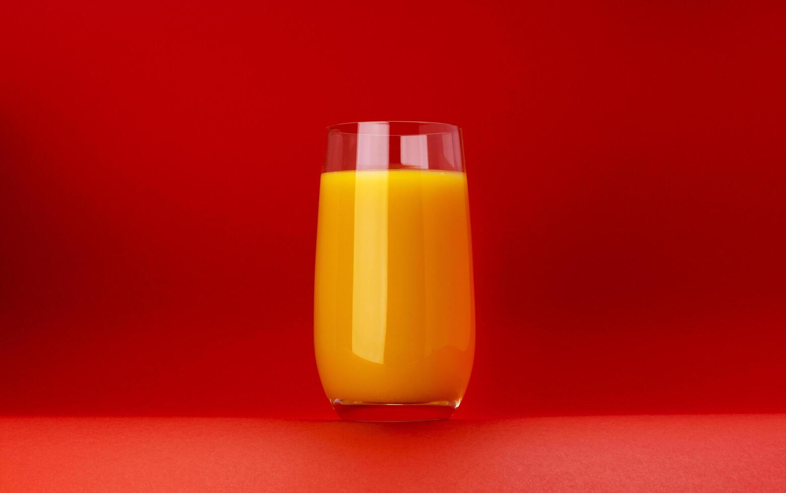 verre de Orange jus isolé sur rouge Contexte avec copie espace photo