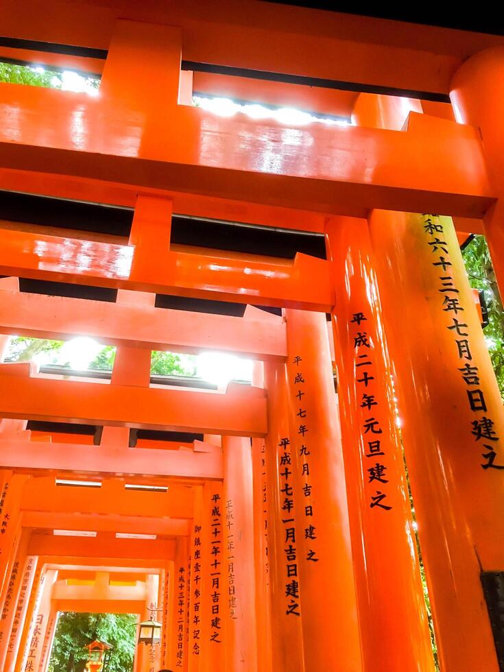 Kyoto, Japon, 2023- Regardez en haut vue rouge en bois poteaux de torii portes à fushimi inari tombeau dans Kyoto. cette est shinto tombeau et un de le plus populaire touristique les destinations dans Japon. photo