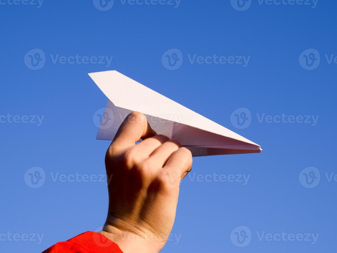 blanc papier avion dans main contre le ciel. une symbole de liberté sur le l'Internet photo