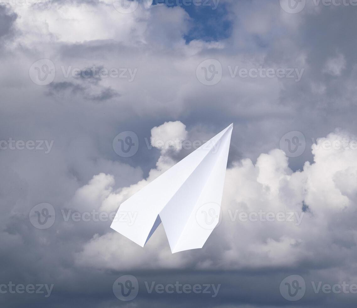 blanc papier avion dans une bleu ciel avec des nuages. le message symbole dans le Messager photo