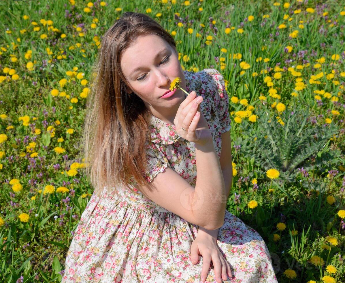 une fille dans une robe dans une clairière avec pissenlits. le fille parmi le fleurs photo