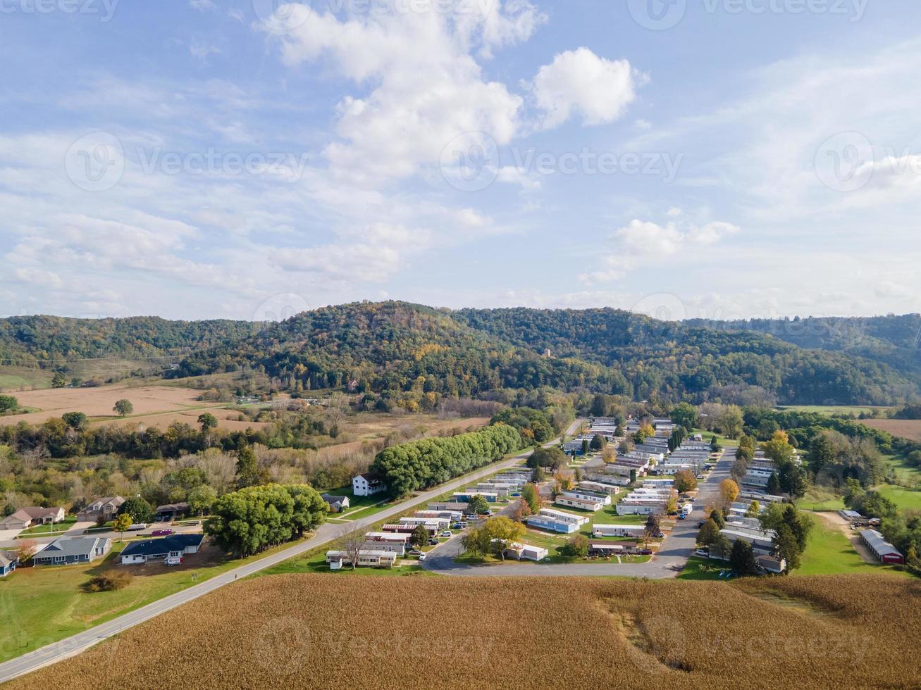 quartier rural et terres agricoles en automne dans les montagnes du Midwest avec des arbres et des champs de ferme paysagers ouverts après la récolte des maisons unifamiliales adaptées aux familles et un parc de maisons mobiles pour la diversité. photo