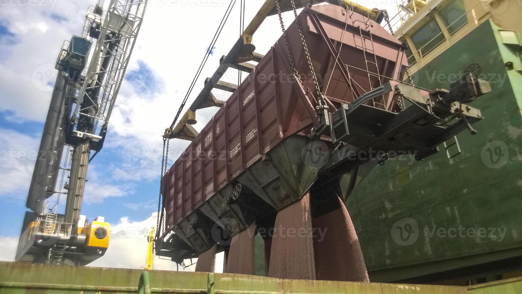 le précipitation de grain de le voiture dans le tenir de le pétrolier. grain remplissage de le cargaison compartiment de le bateau. photo