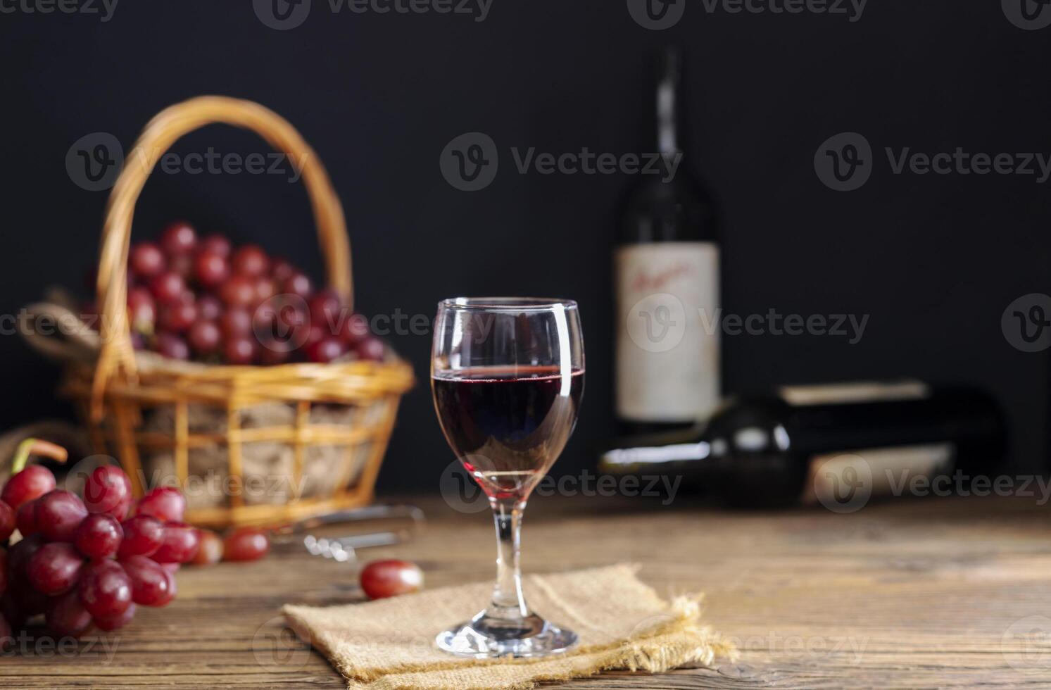 rouge grain de raisin jus dans une verre mis sur une en bois table ou rouge vin, une délicieux Naturel en bonne santé jus boire. avec une bouquet de Frais rouge les raisins de le jardin photo