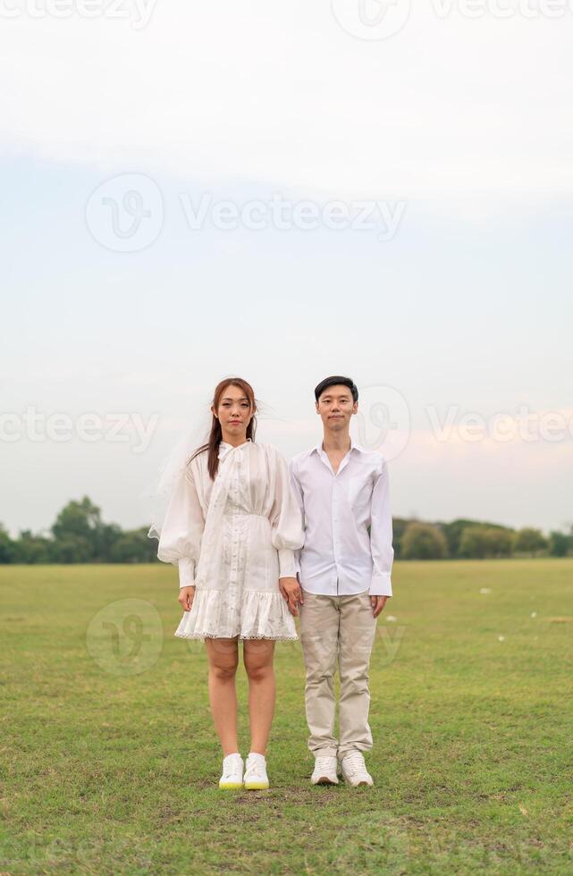 heureux jeune couple asiatique en vêtements de mariée et de marié photo